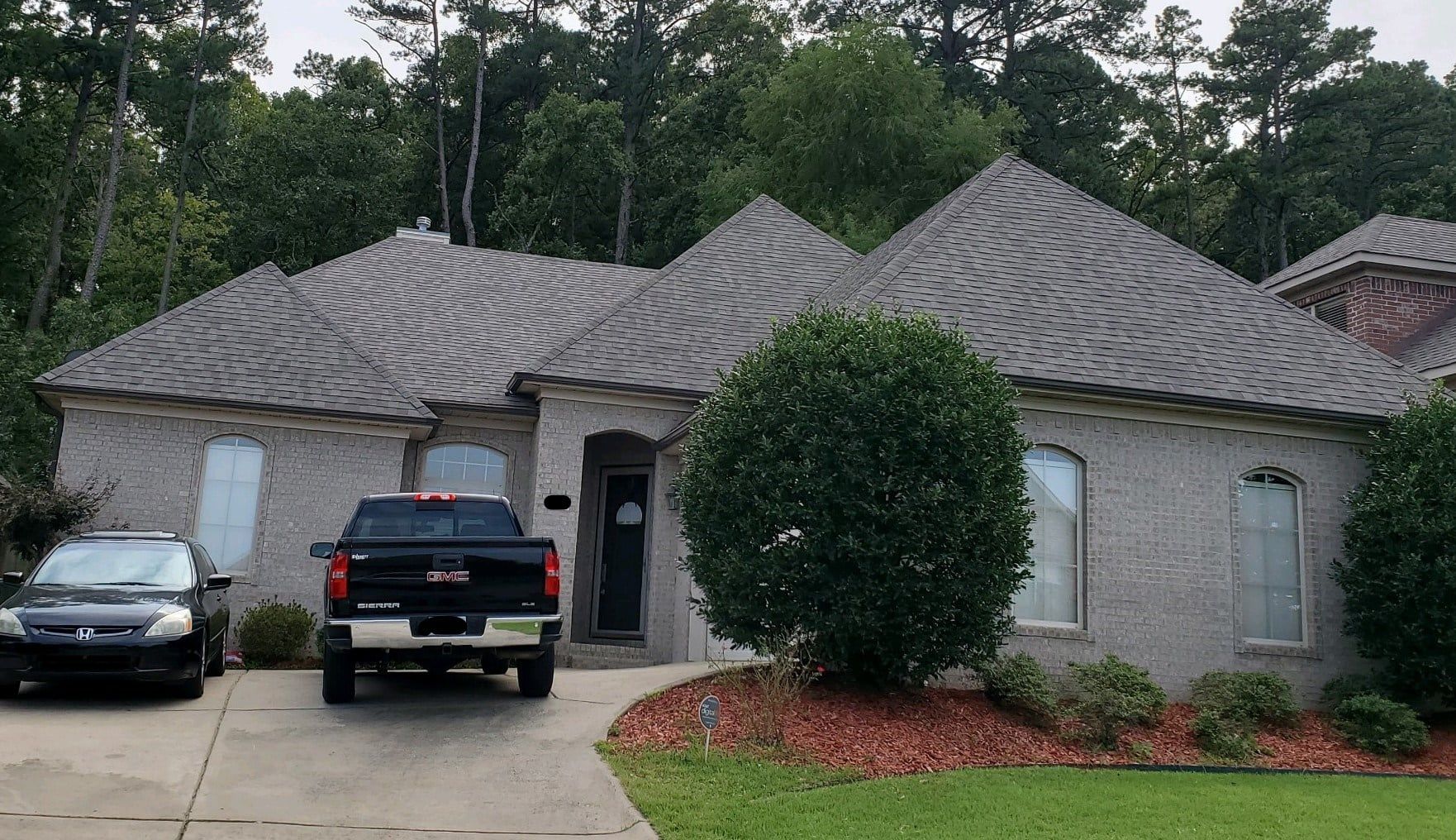 A black truck is parked in front of a house.