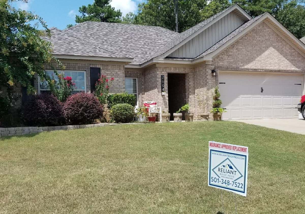 A house with a for sale sign in front of it.
