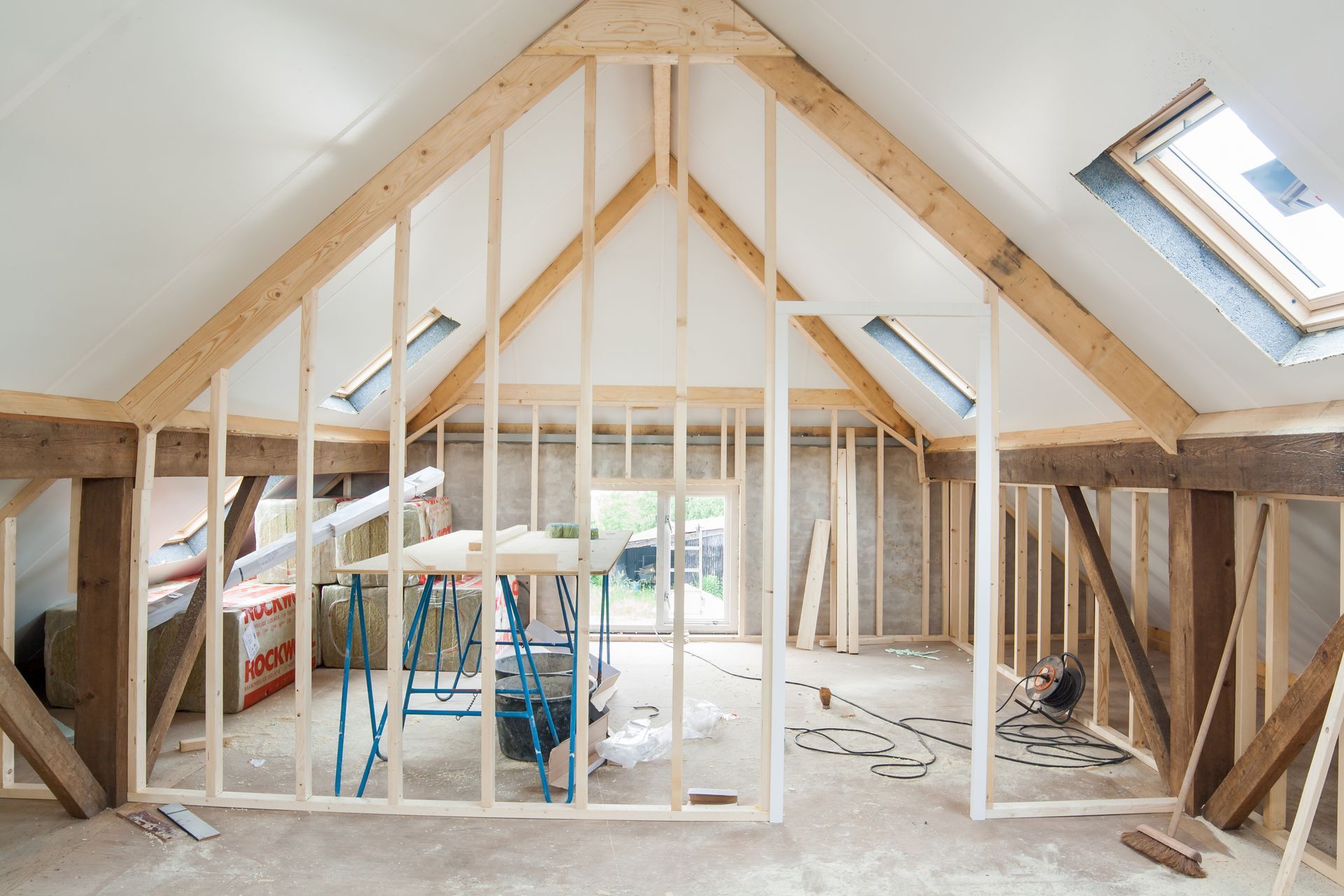 A room that is being built with wooden beams and a skylight.