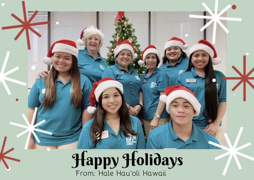 A group of people wearing santa hats are posing for a picture in front of a christmas tree.