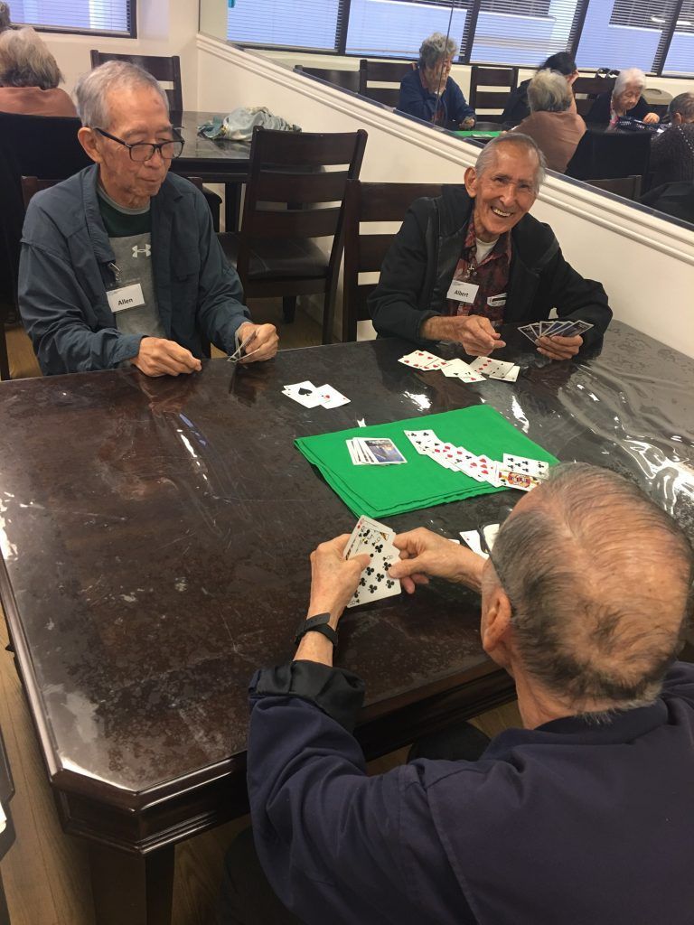 A group of men are sitting at a table playing cards.