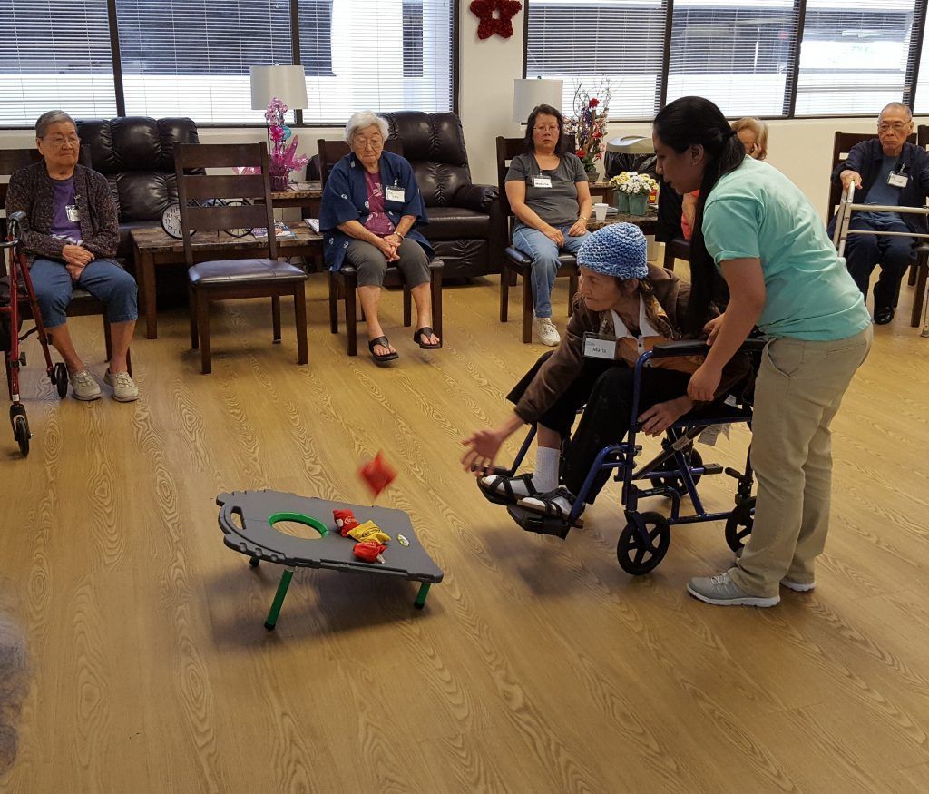 A woman in a wheelchair is playing a game with other people.