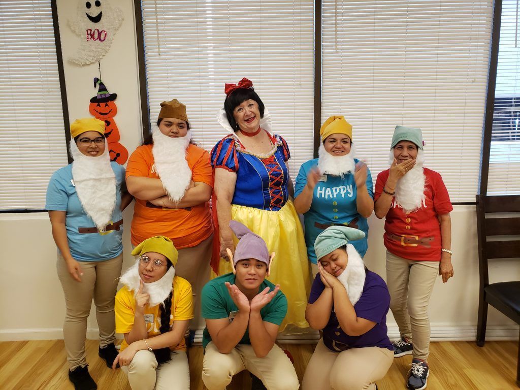 A group of people dressed as snow white and the seven dwarfs are posing for a picture.