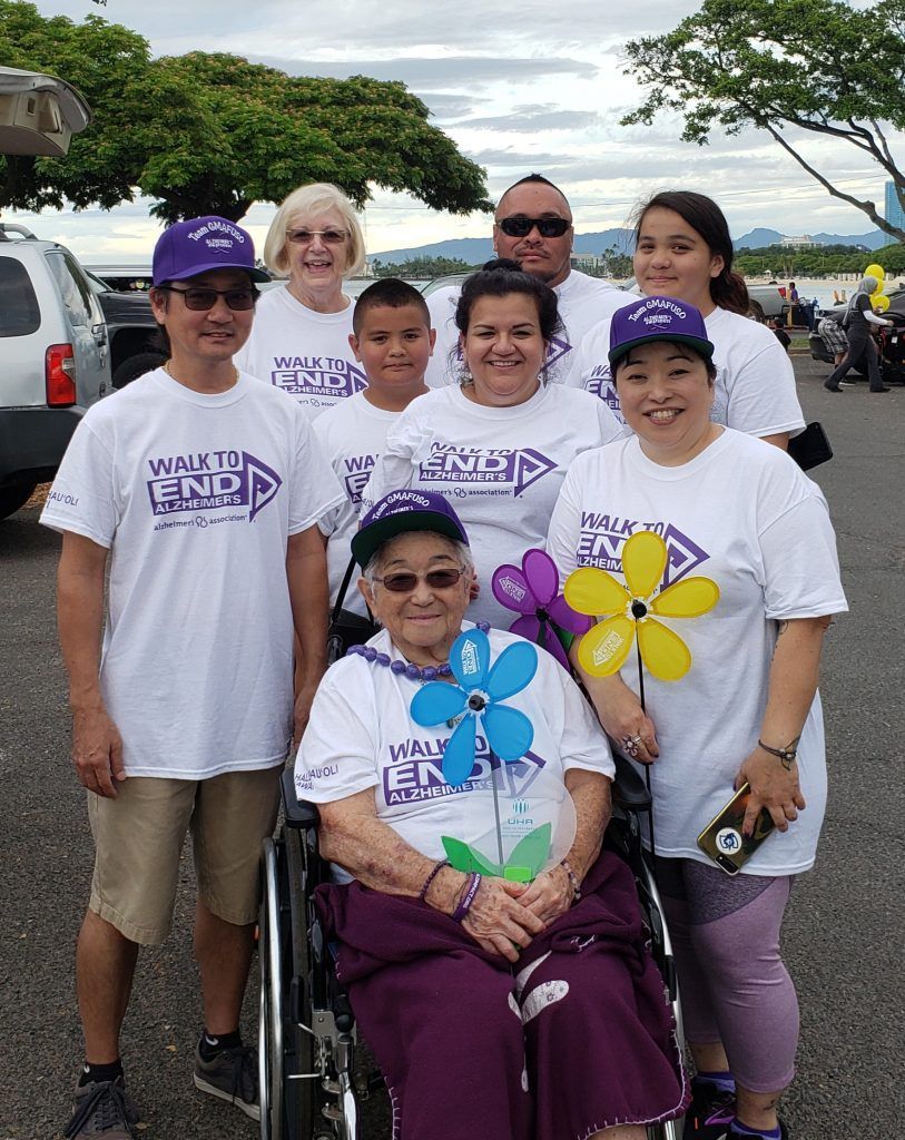 A group of people standing around a woman in a wheelchair.