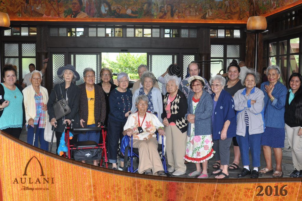 A group of elderly women are posing for a picture in a room.