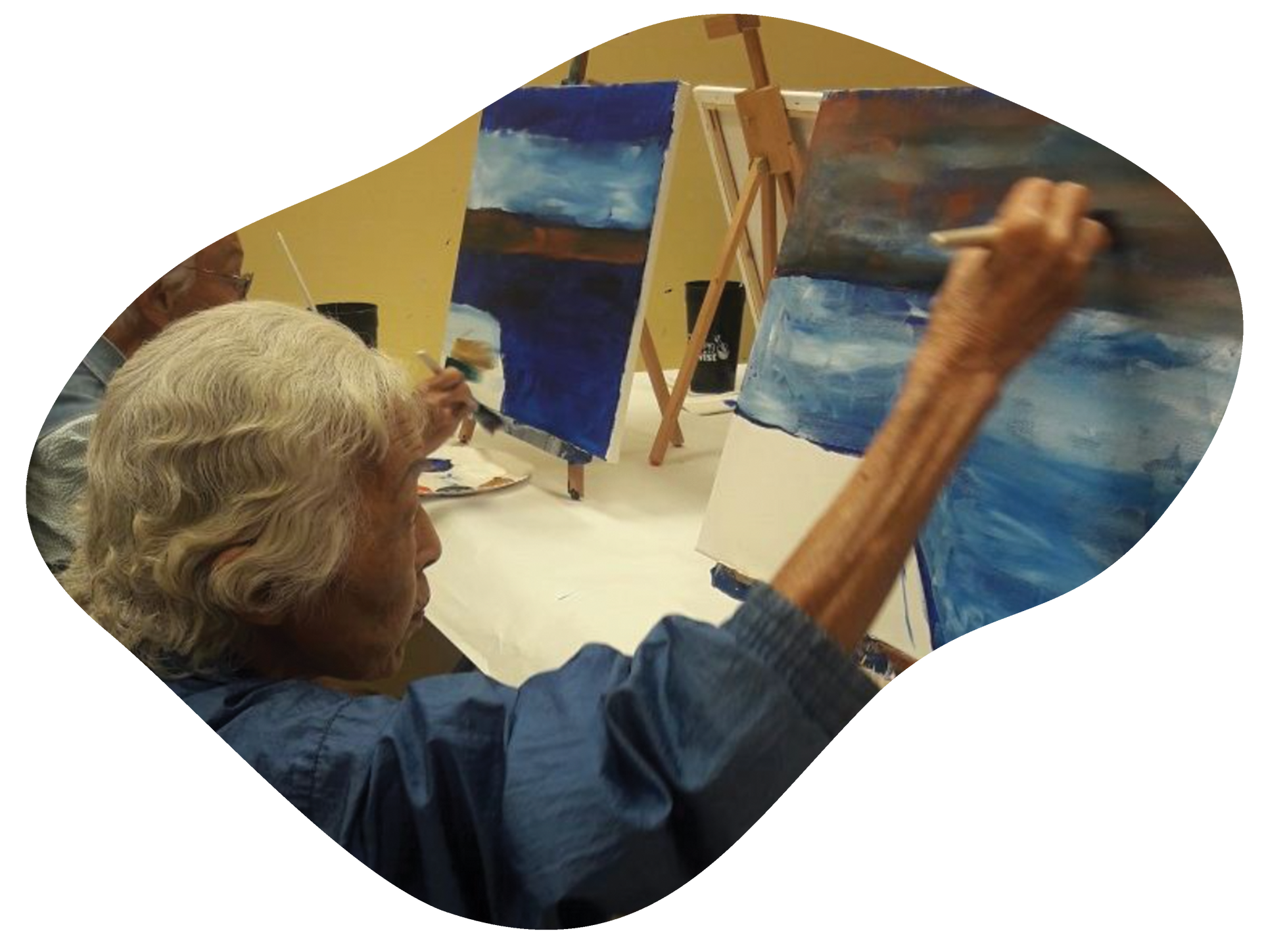 A woman is painting a picture on an easel