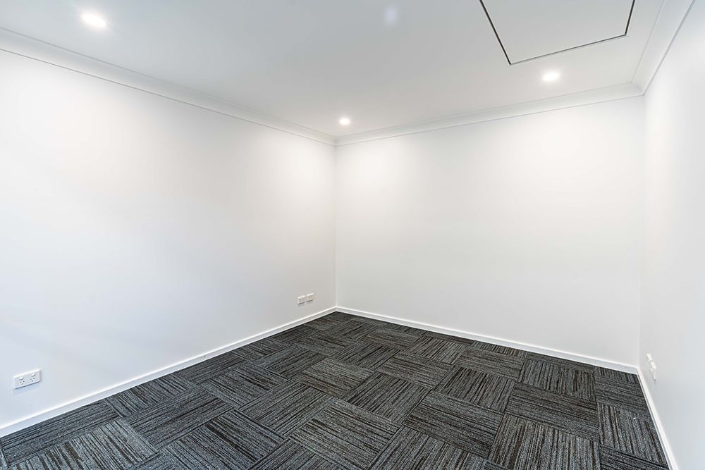 An Empty Room with A Black Carpet and White Walls — Construction & Renovation Services in Dubbo, NSW