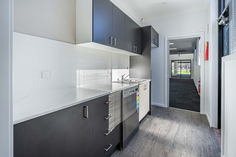 A Kitchen with Black and White Cabinets and A Sink — Construction & Renovation Services in Dubbo, NSW