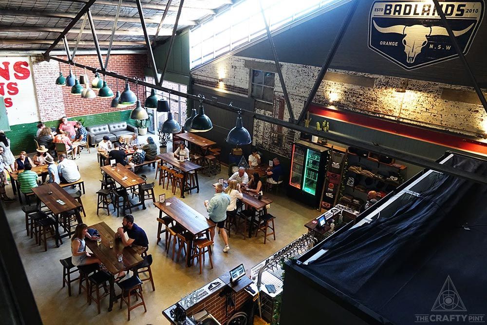 A Group of People Are Sitting at Long Tables in A Restaurant — Construction & Renovation Services in Dubbo, NSW