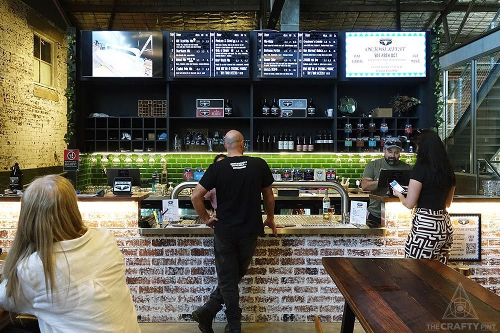 A Man and A Woman Are Standing at A Counter in A Restaurant — Construction & Renovation Services in Dubbo, NSW