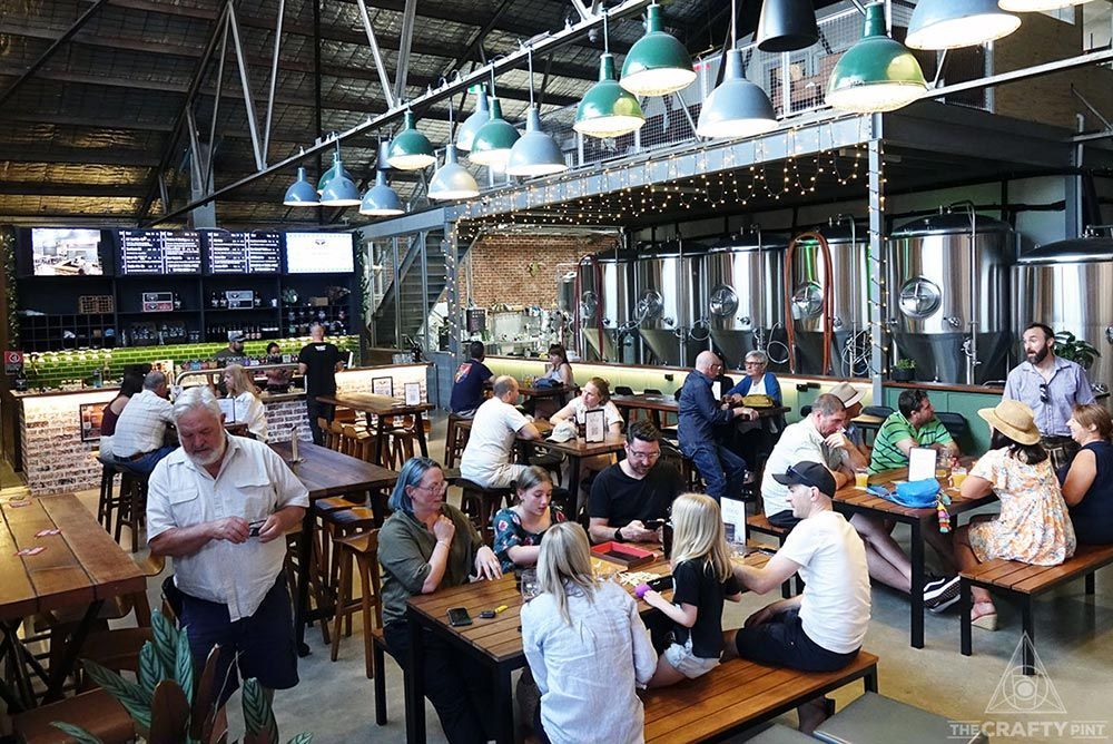 A Group of People Are Sitting at Tables in A Restaurant — Construction & Renovation Services in Dubbo, NSW