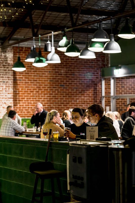 A Group of People Are Sitting at A Table in A Restaurant — Construction & Renovation Services in Dubbo, NSW