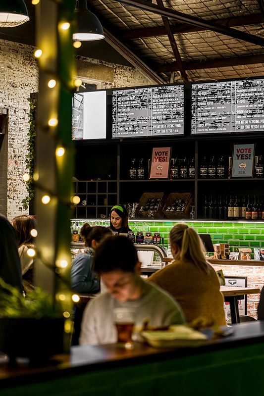 A Group of People Are Sitting at Tables in A Restaurant — Construction & Renovation Services in Dubbo, NSW