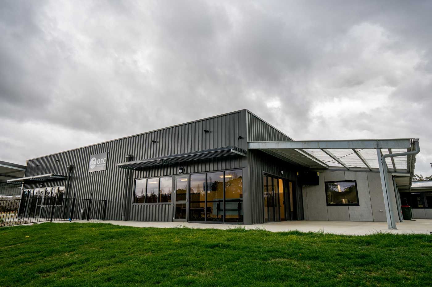 A Large Building With A Lot Of Windows Is Sitting On Top Of A Lush Green Field — BLD Constructions in Dubbo, NSW