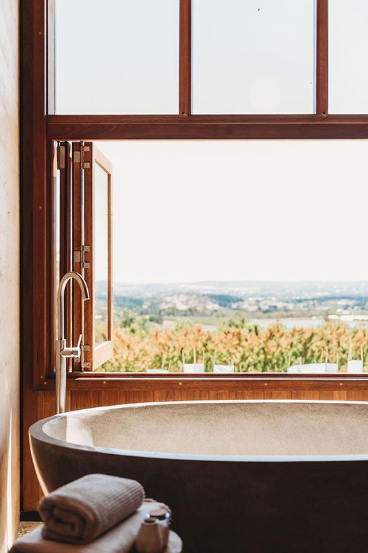 A Bathroom with A Bathtub and A Window with A View of A Vineyard — Construction & Renovation Services in Dubbo, NSW