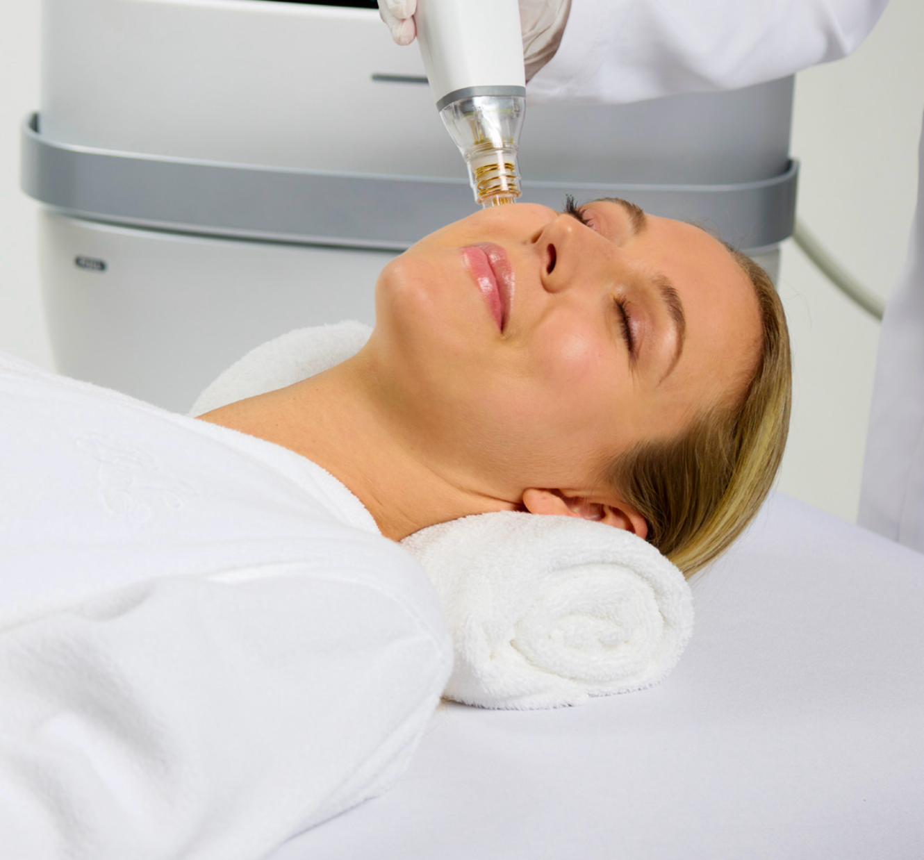 A woman is getting a treatment on her face