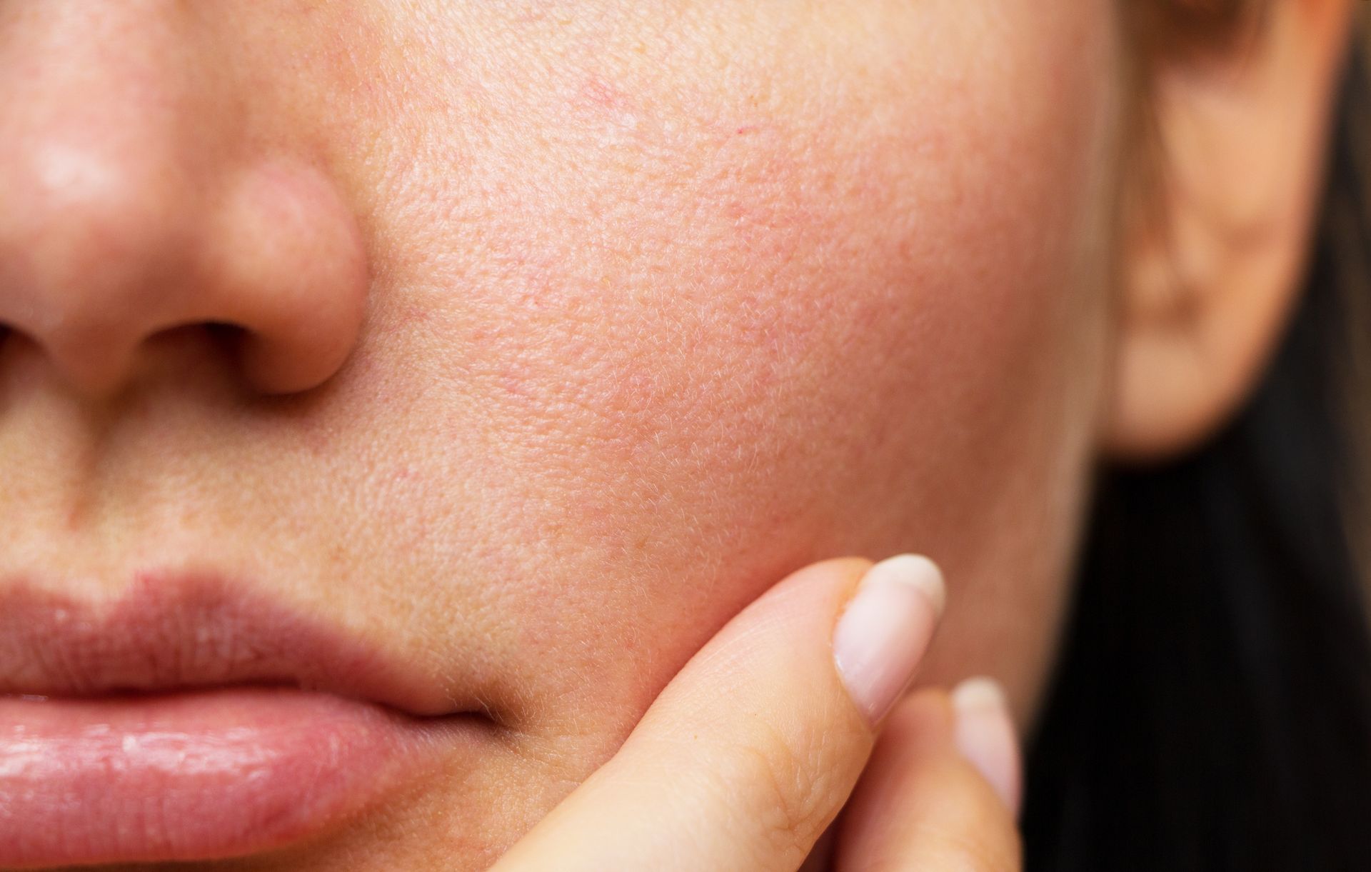 A close up of a woman 's face with a hand on it.