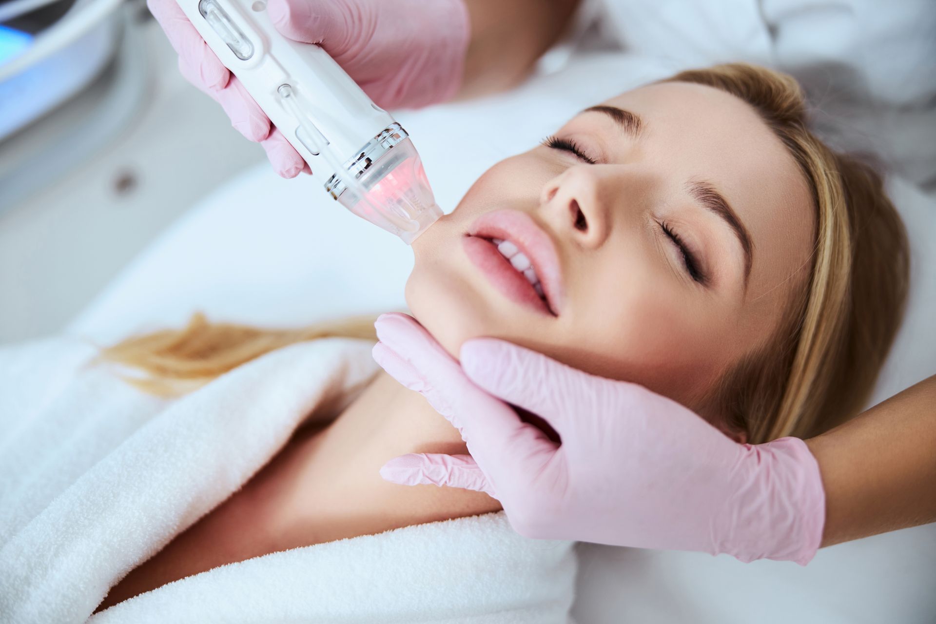A woman is getting a facial treatment at a beauty salon.