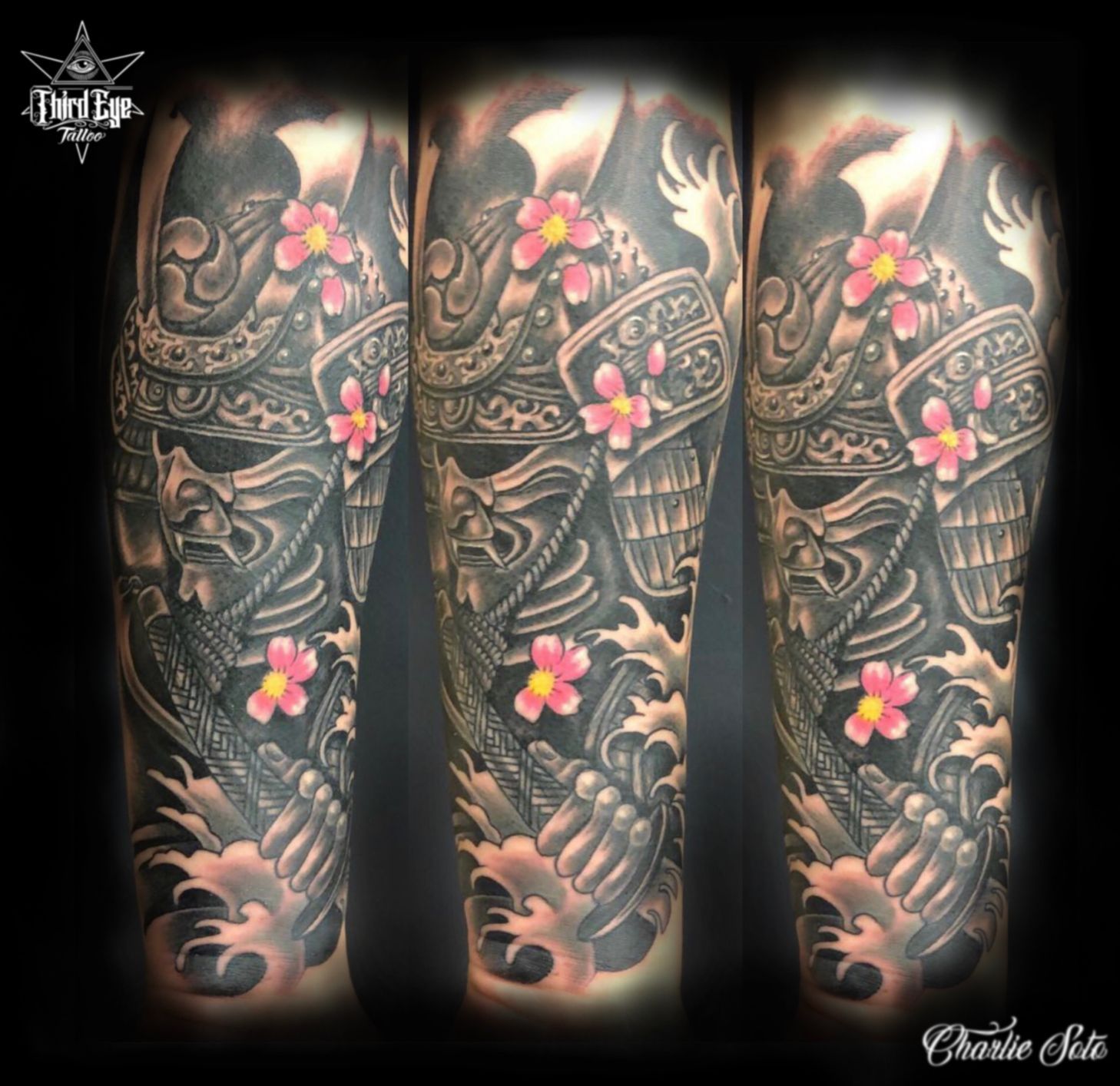 Samurai helmet and skeleton arm tattoo with pink cherry blossoms, on an arm.