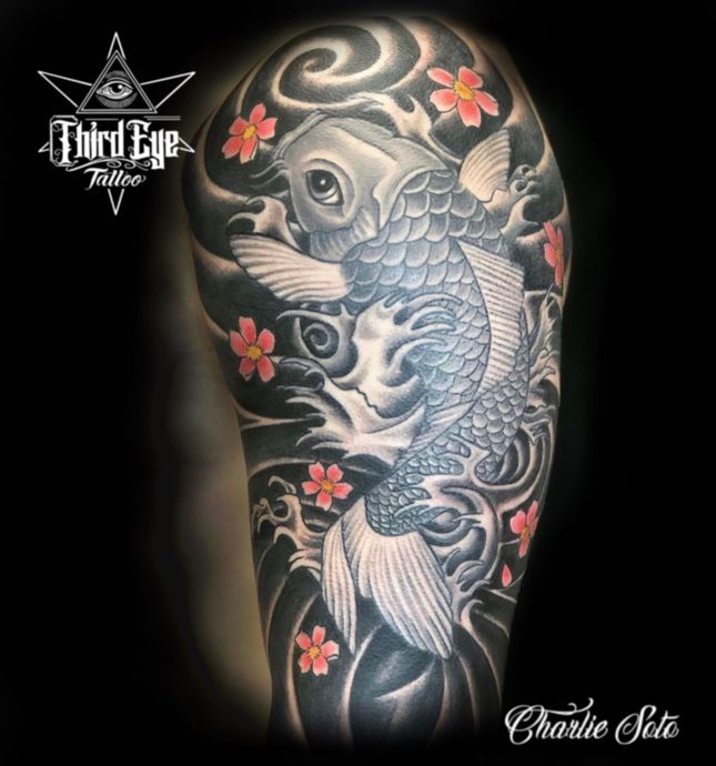 A tattoo of a fish and flowers by third eye tattoo