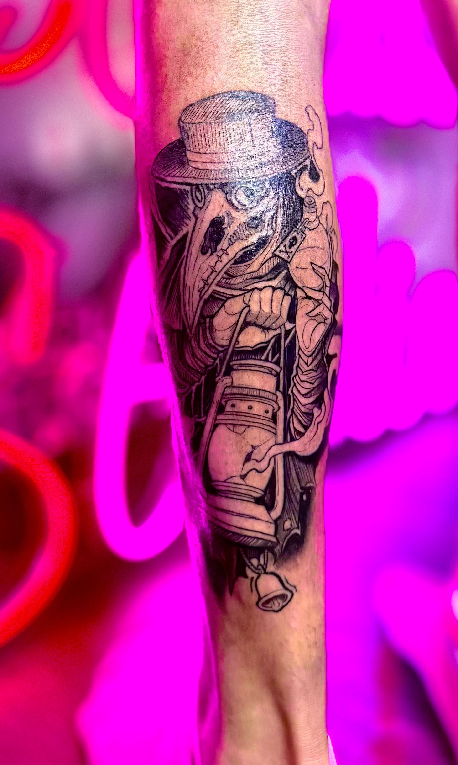 Black and white tattoo of a plague doctor holding a lantern on a forearm.