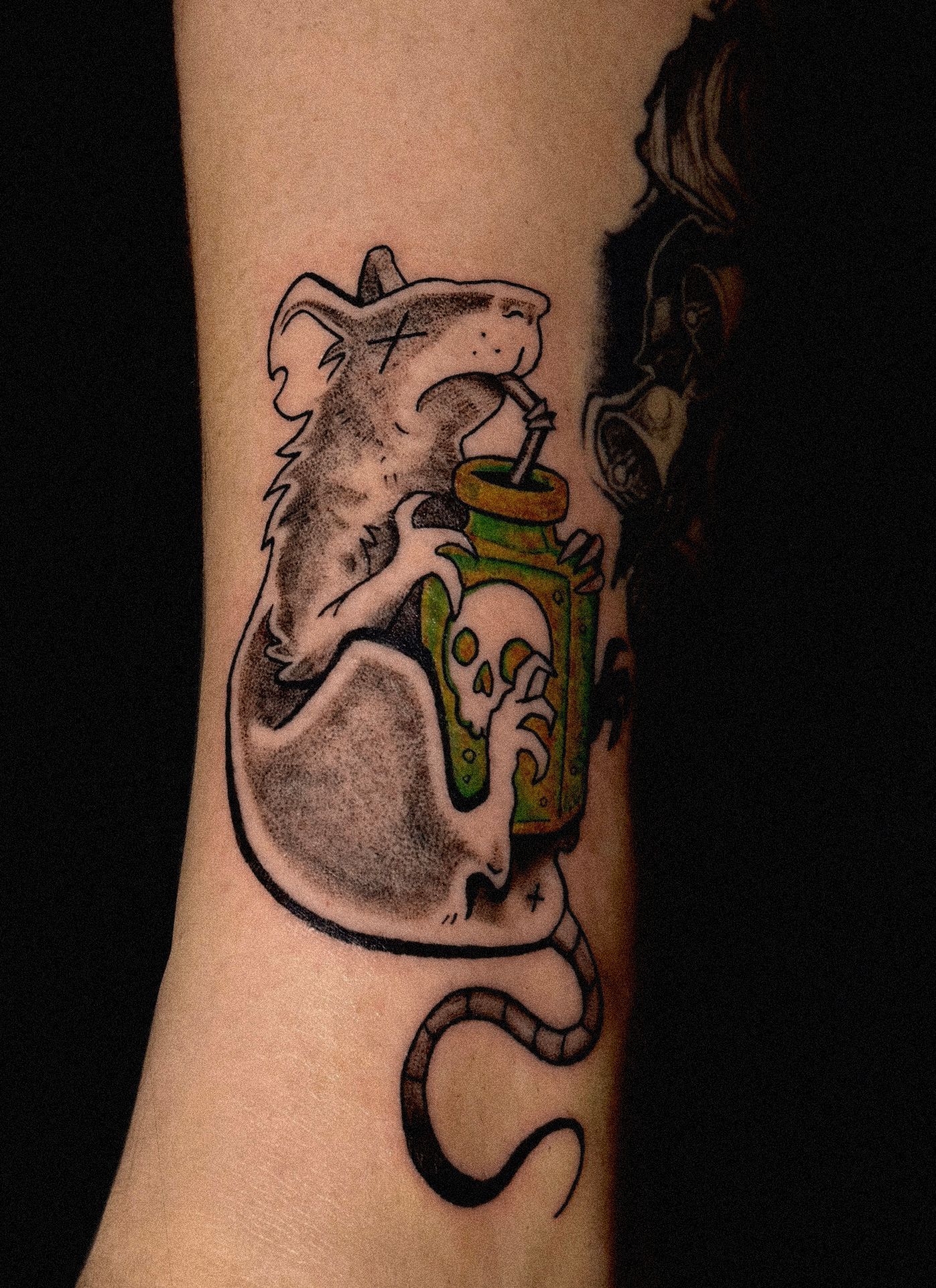 Tattoo of a rat drinking from a poison bottle, with a skull and crossbones.