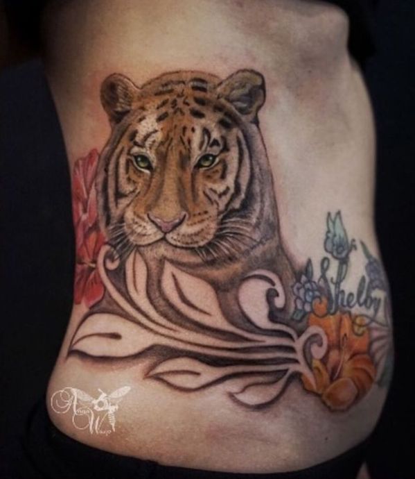 A woman has a tattoo of a tiger on her side
