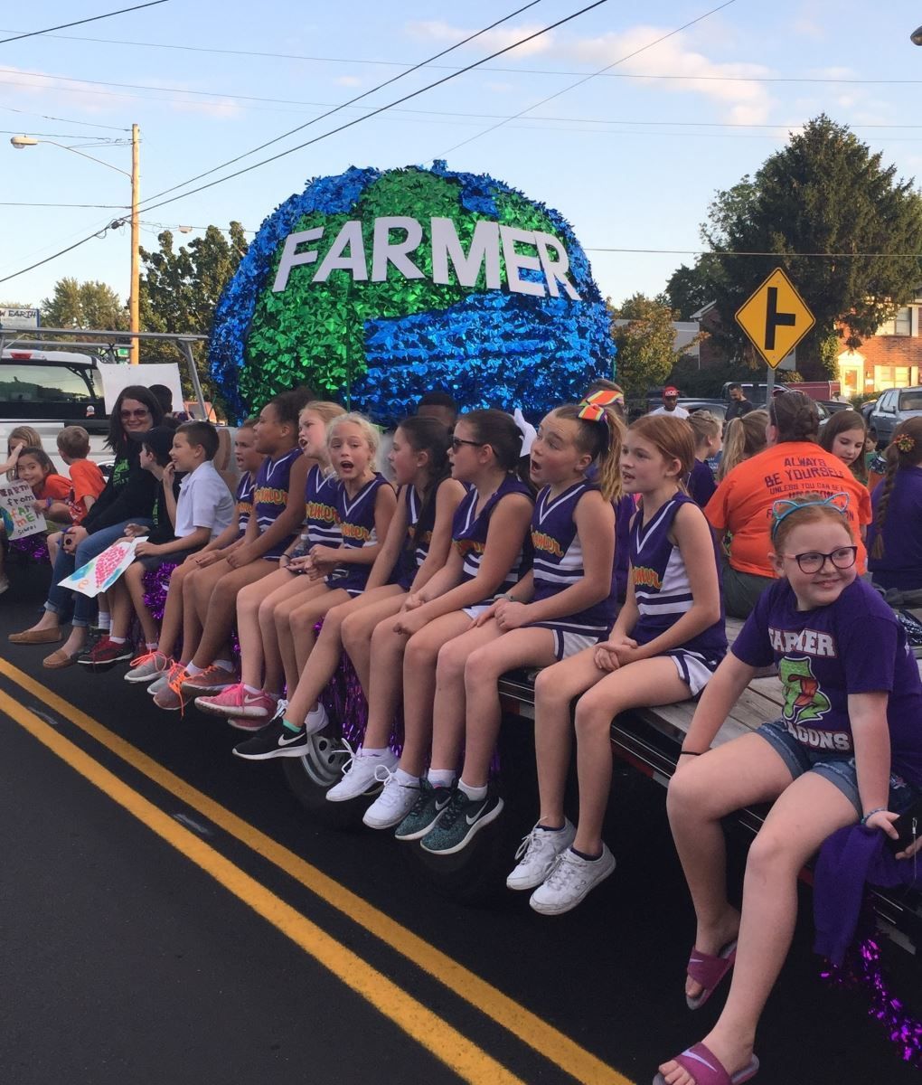 a group of children sit on a float that says farmer