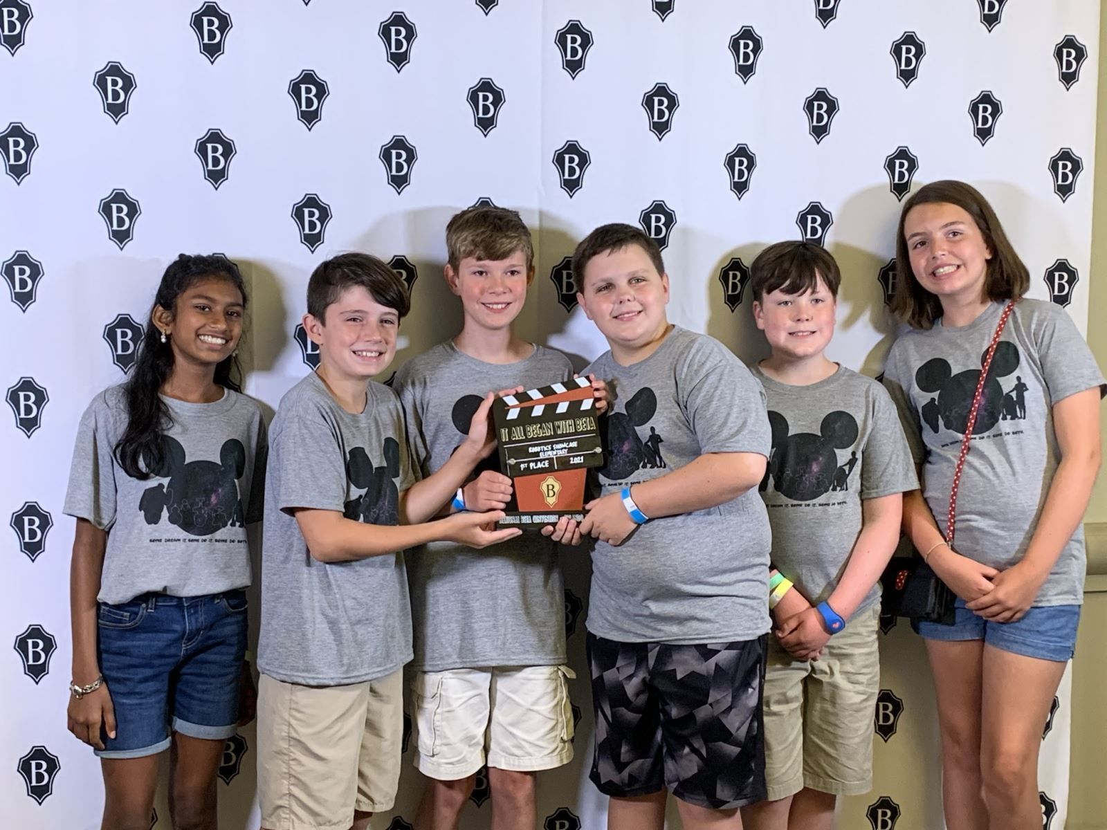 a group of young people standing next to each other holding a clapper board .