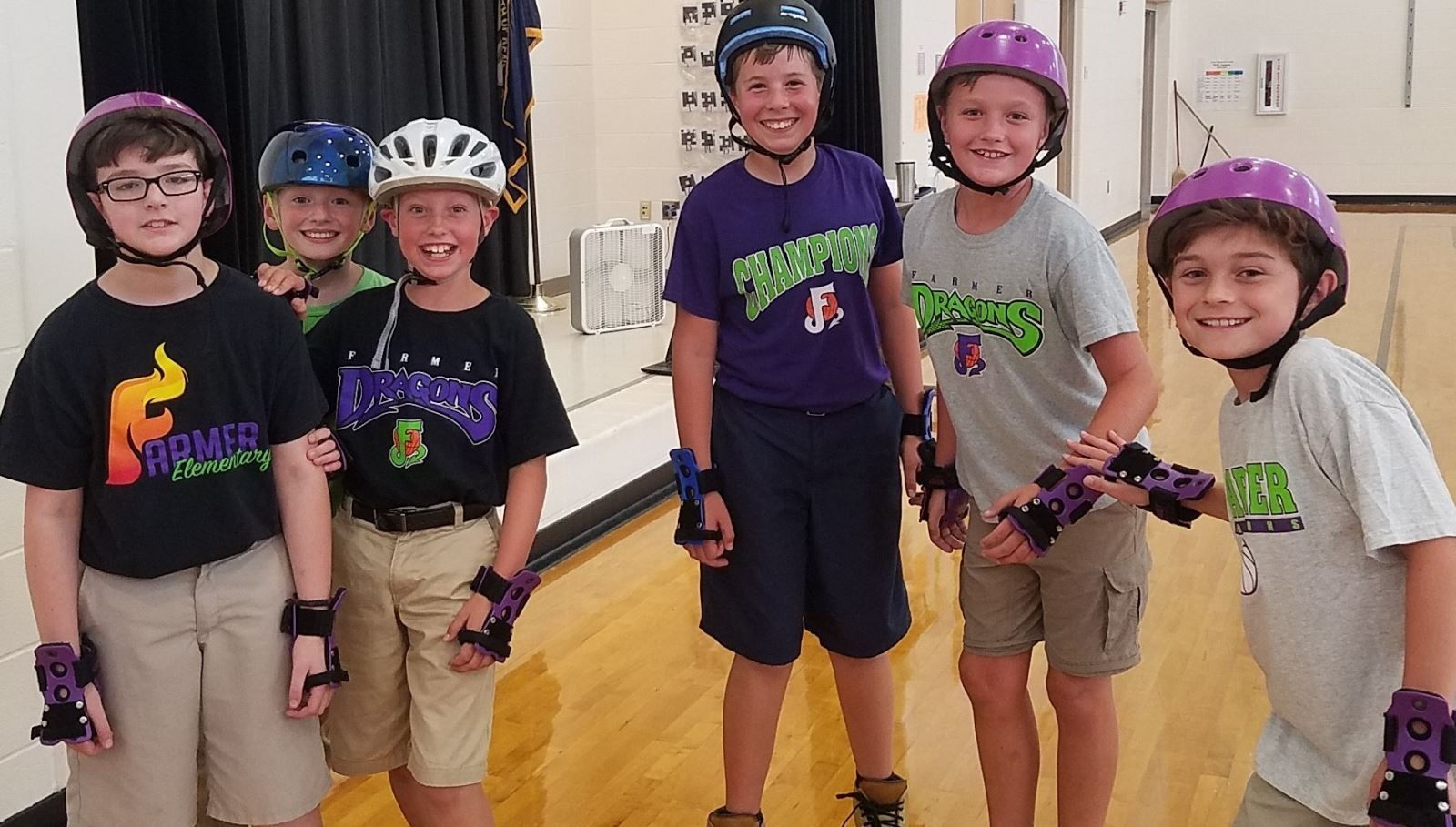 a group of young boys wearing roller skates and helmets pose for a picture