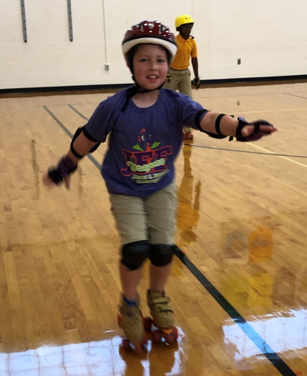 a young boy wearing roller skates and a helmet
