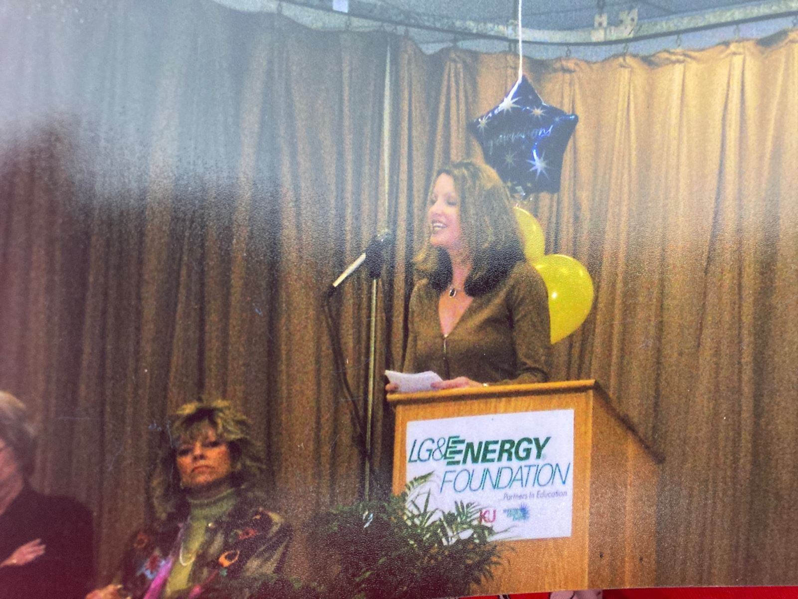 a woman stands at a podium that says igenergy foundation