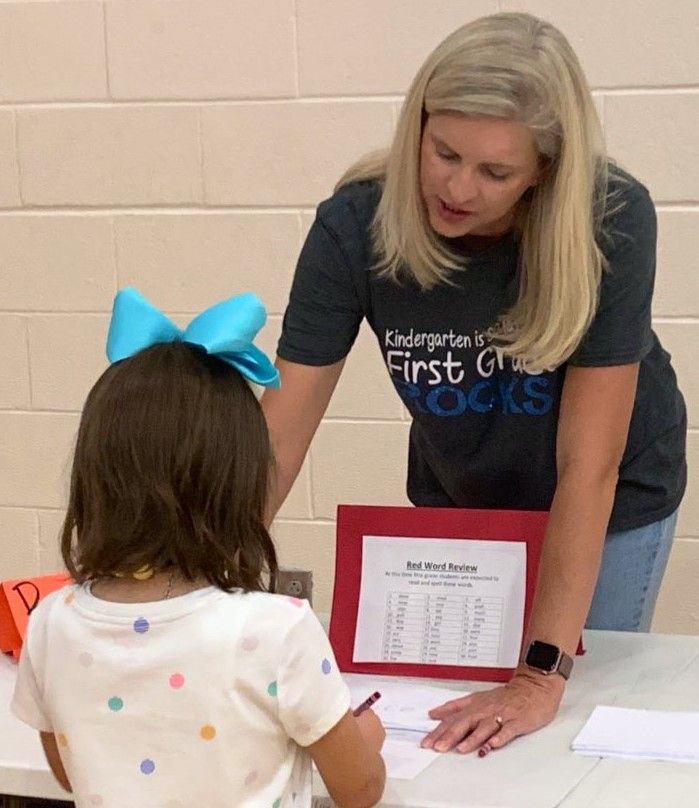 a woman wearing a shirt that says kindergarten is first grade