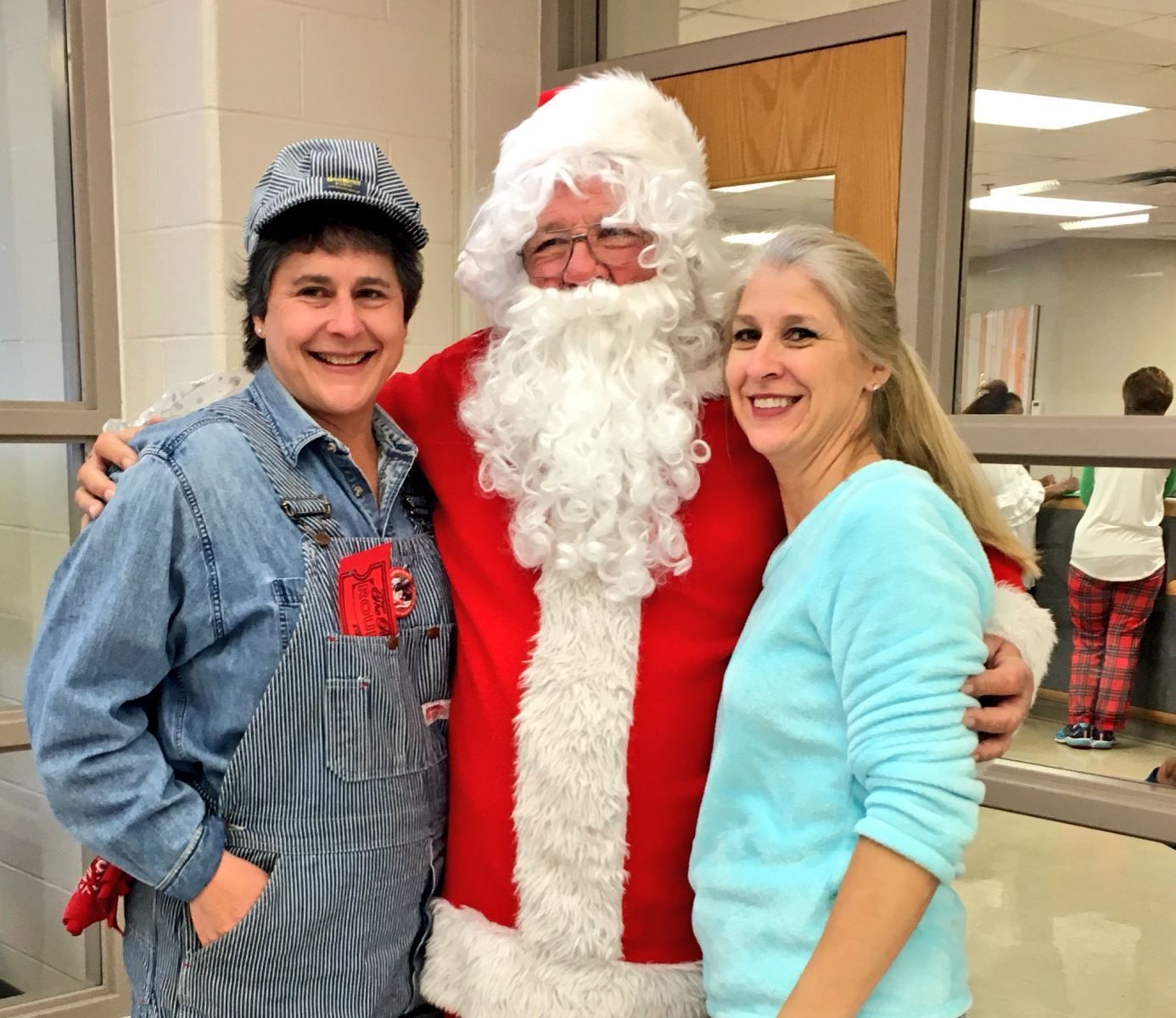 a man dressed as santa claus is posing for a picture with two women .