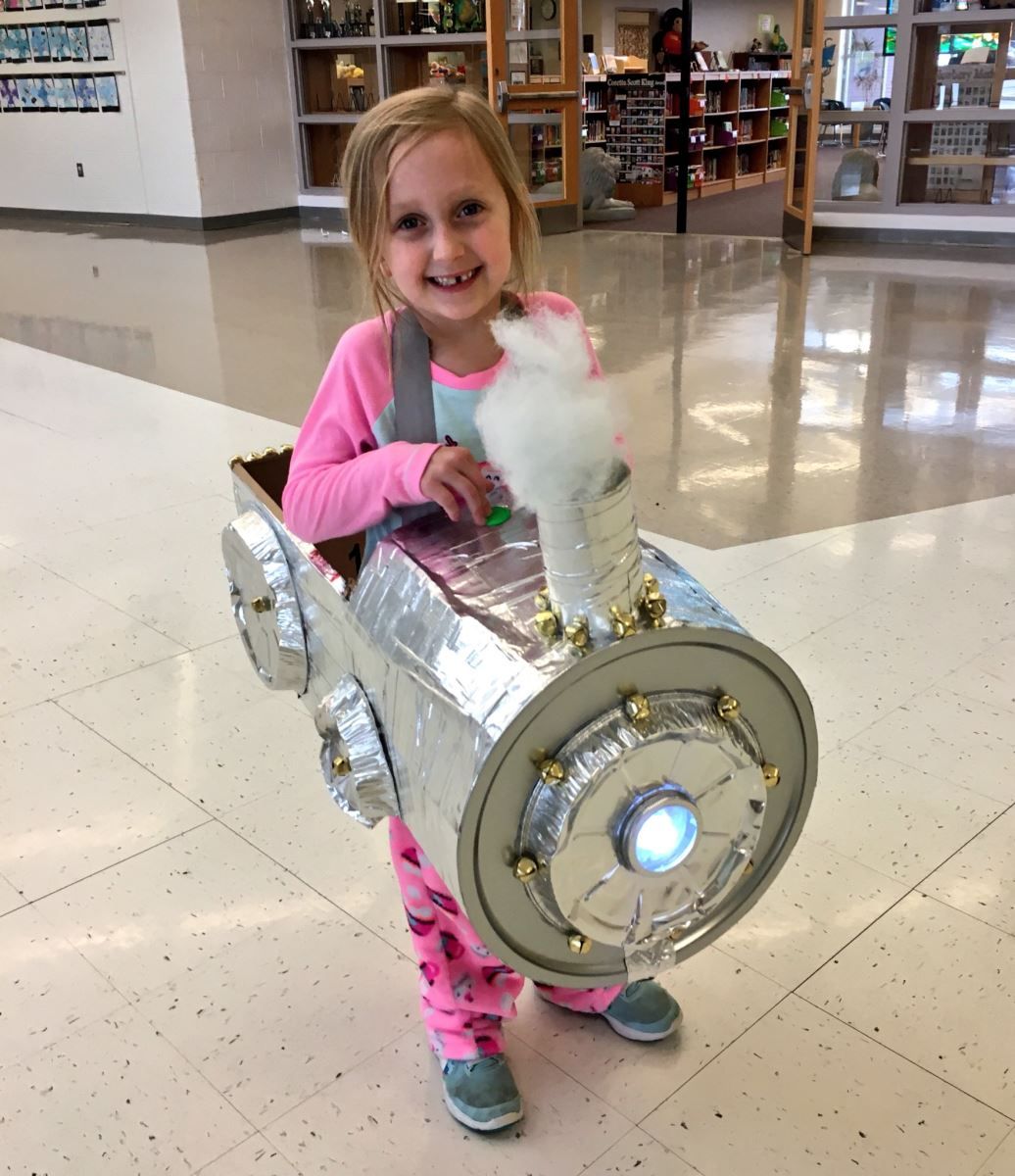 a little girl is wearing a costume that looks like a train engine