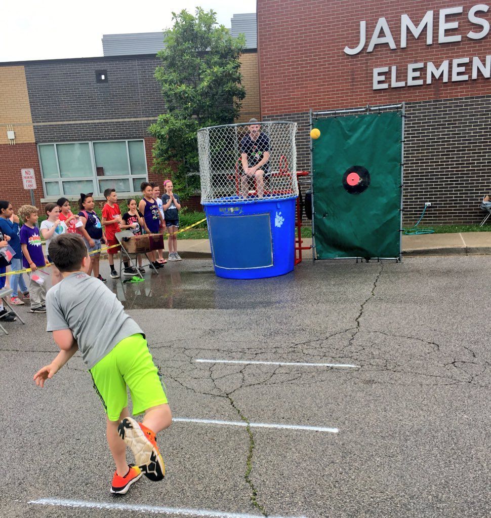a boy is throwing a ball in front of james elementary school