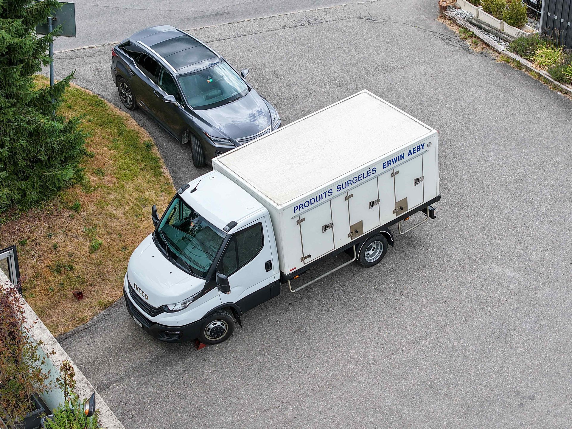 Un camion blanc est garé sur le bord de la route à côté d'une voiture.