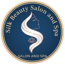 Silk Beauty Salon and Spa logo. Blue circle with text and a woman's profile intertwined with a white S shape, a small lotus flower.