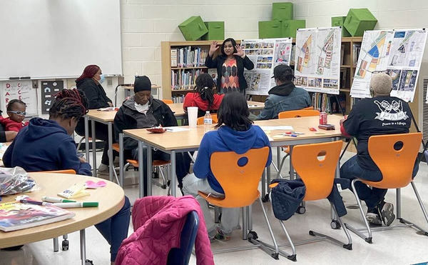 a person standing in front of a group of people sitting at tables