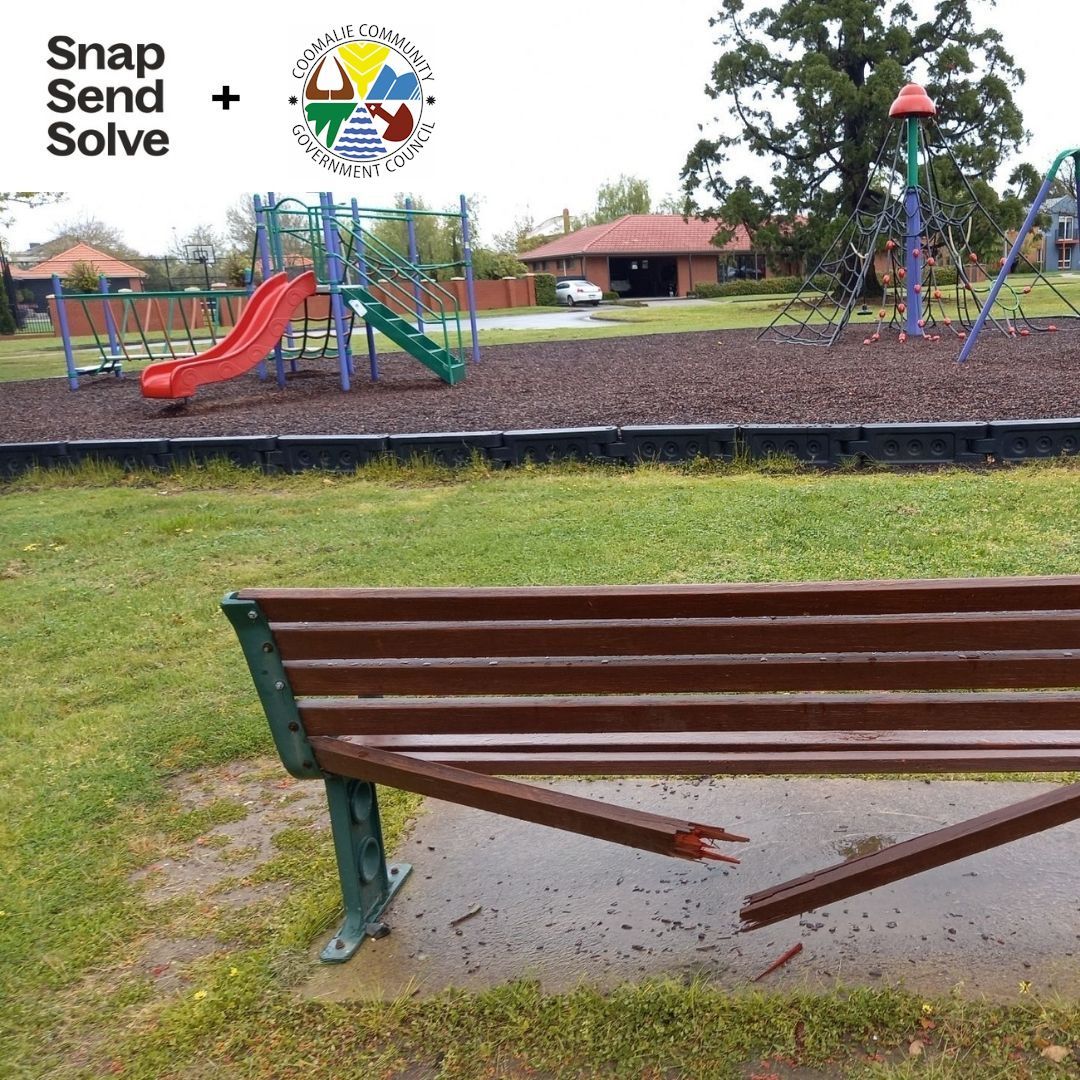A broken bench in front of a playground that says snap send solve