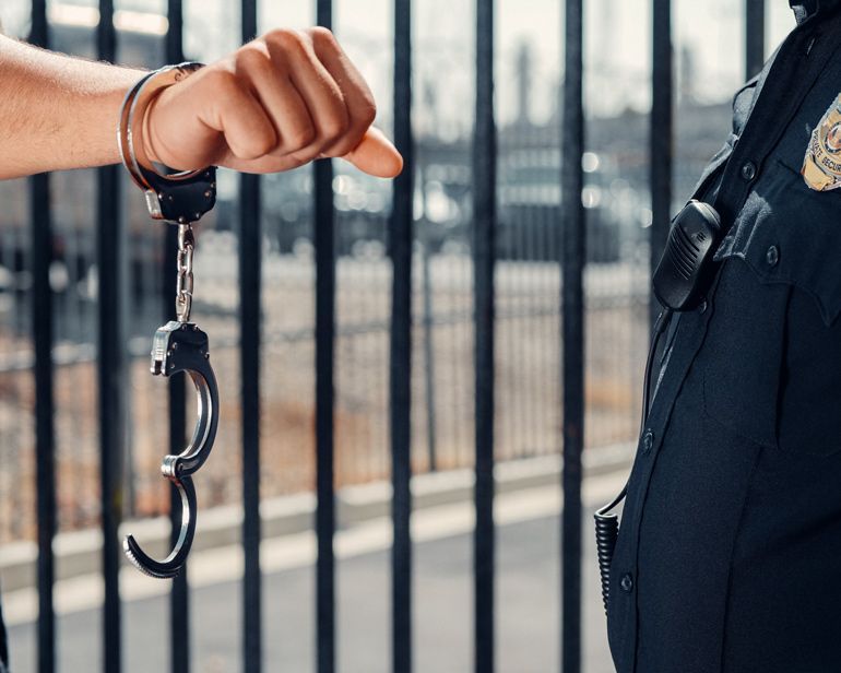 Person presenting handcuffs to police officer
