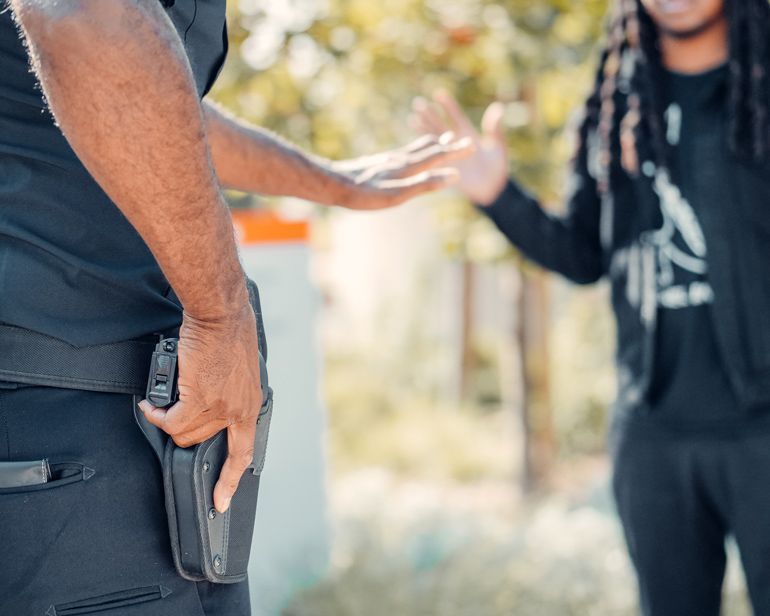 police officer giving orders to person with hand on gun