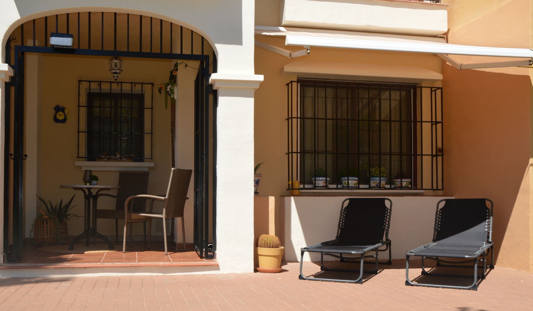 Een terras met stoelen en een tafel voor een huis