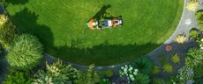 An aerial view of a person laying on a lawn in a park.