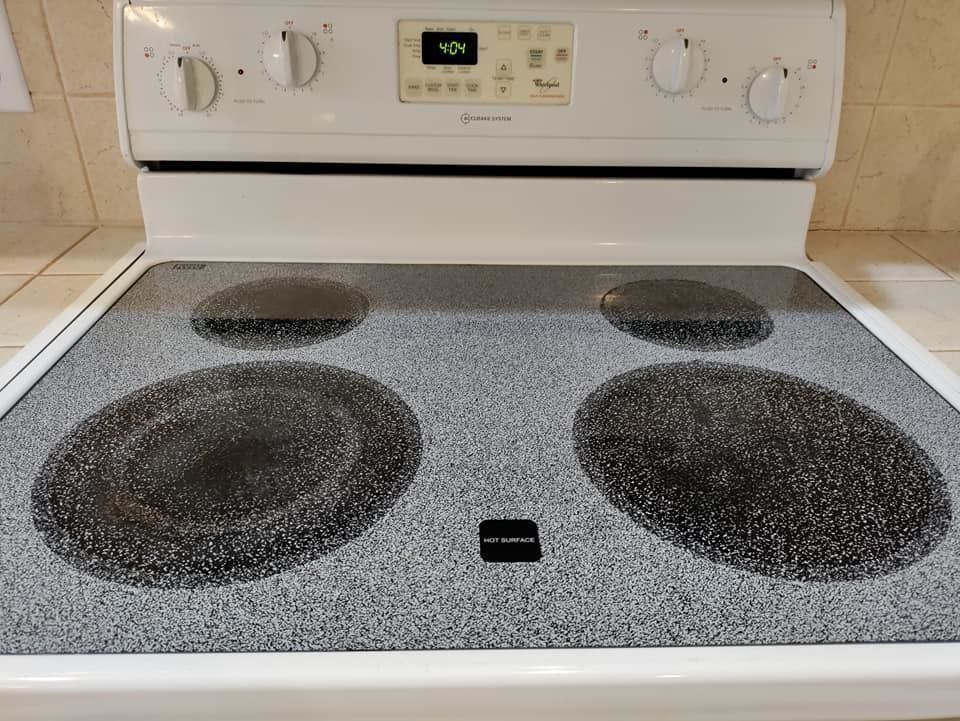 A white stove top oven with a dirty stove top