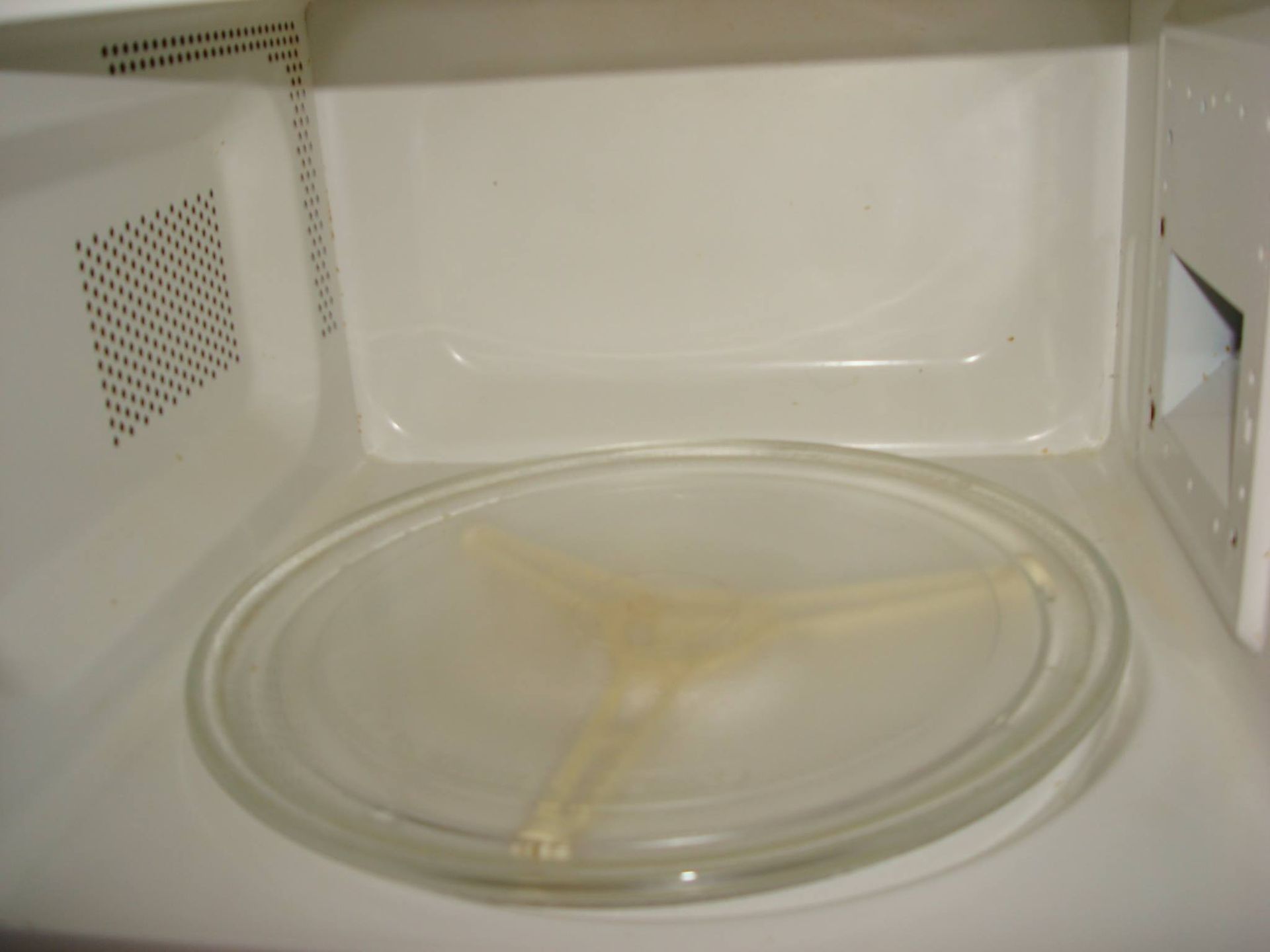 The inside of a microwave with a glass plate in it