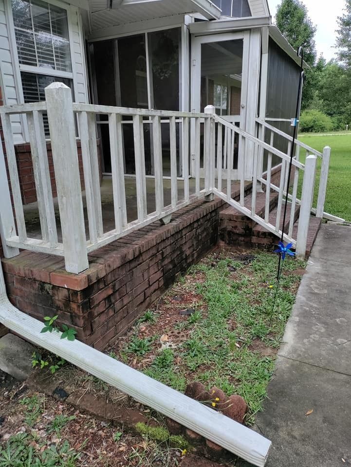 A porch with a broken railing and a gutter on the side of it.