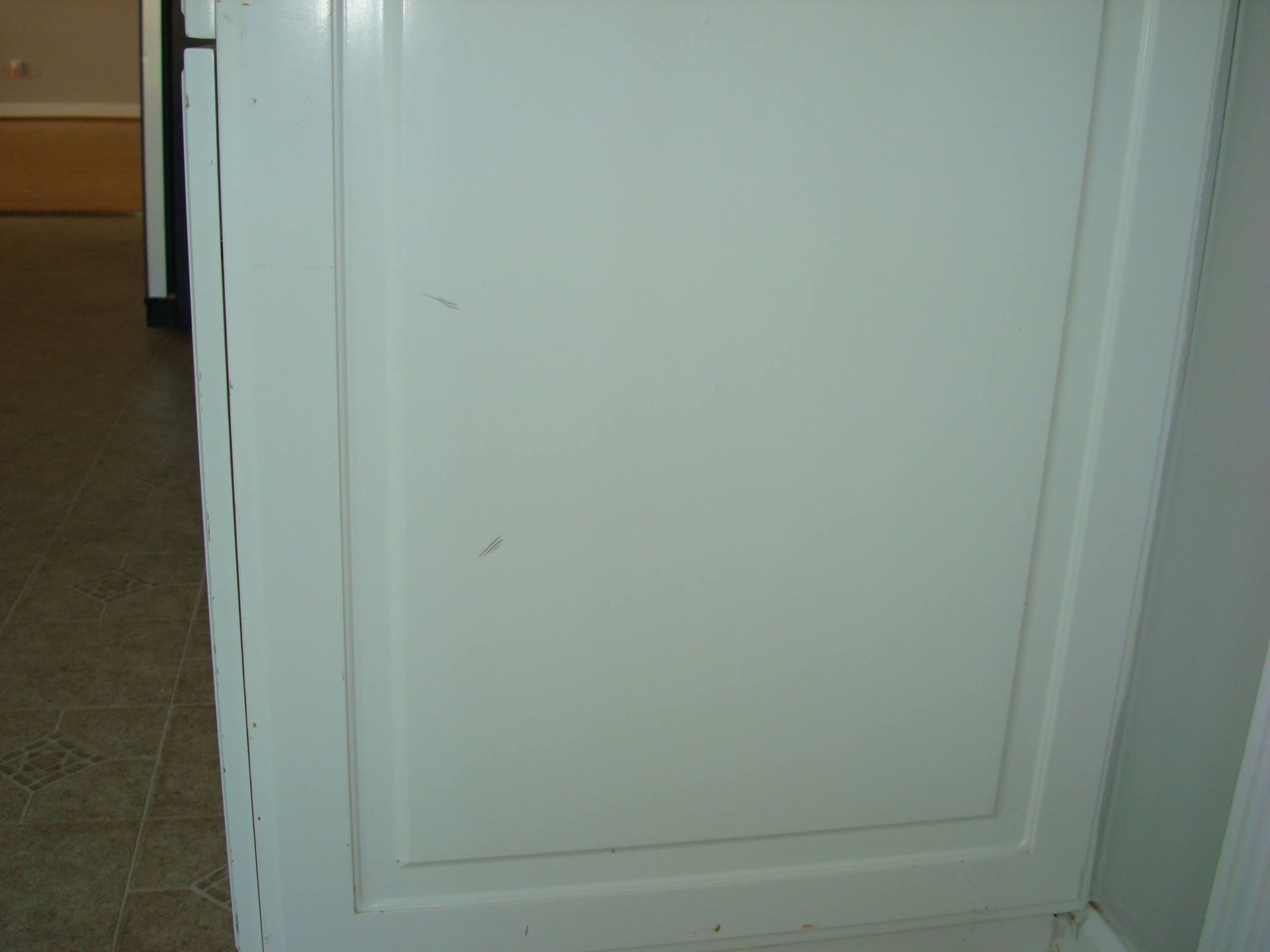 A close up of a white cabinet door in a kitchen.