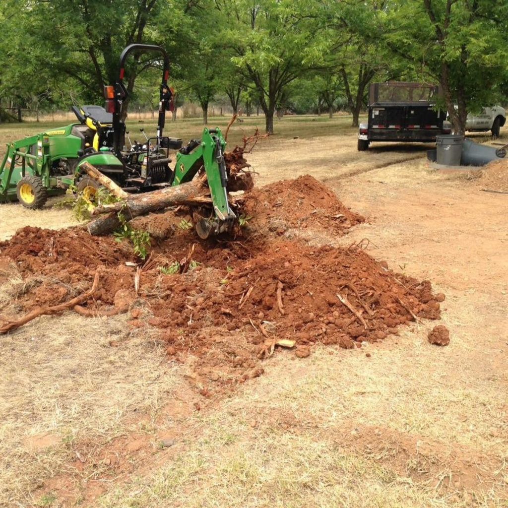 A Green Tractor Is Digging a Hole in The Dirt - Oroville, CA - JR Landscaping 