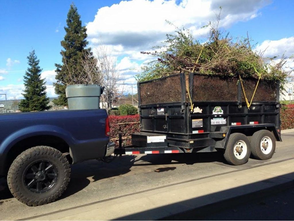A Blue Truck Is Pulling a Trailer Full of Trash - Oroville, CA - JR Landscaping